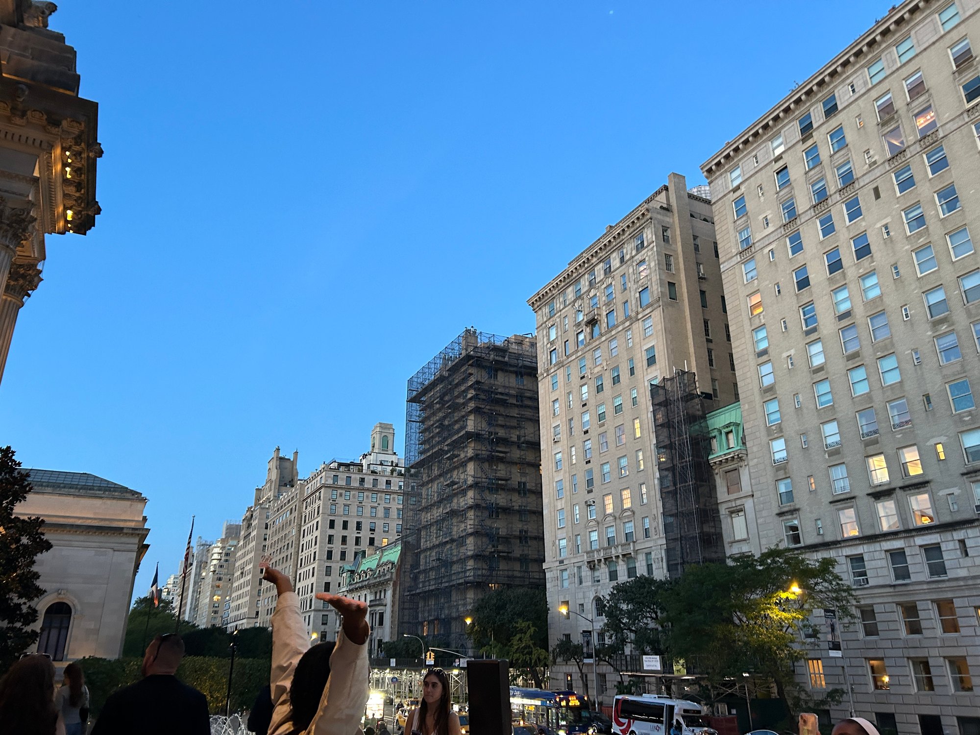 City buildings and a busy street beneath a blue evening sky